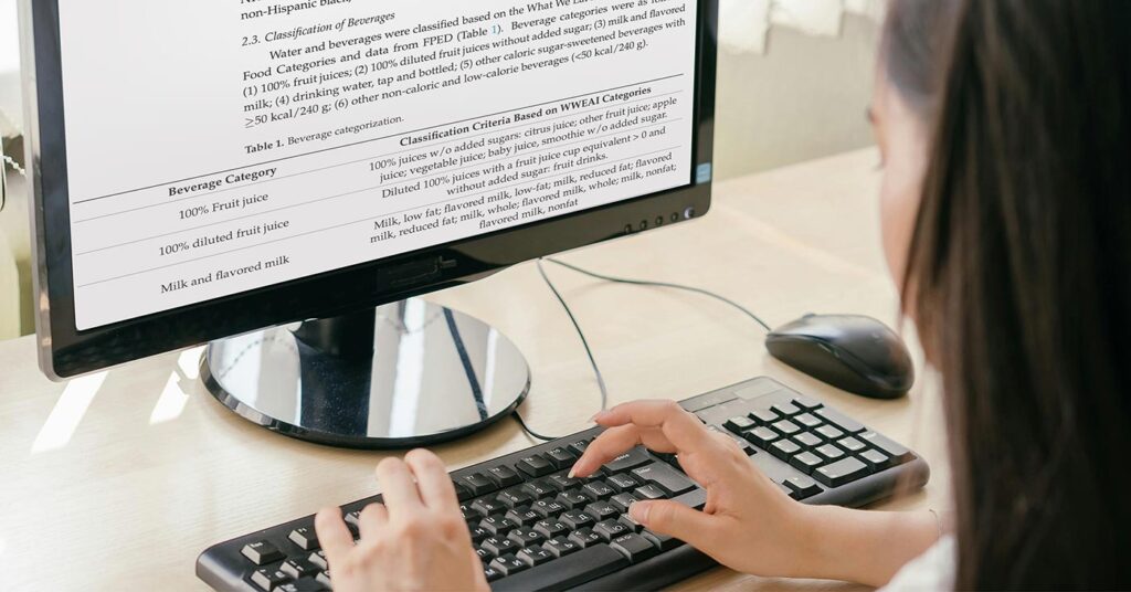 A person researching orange juice on a computer